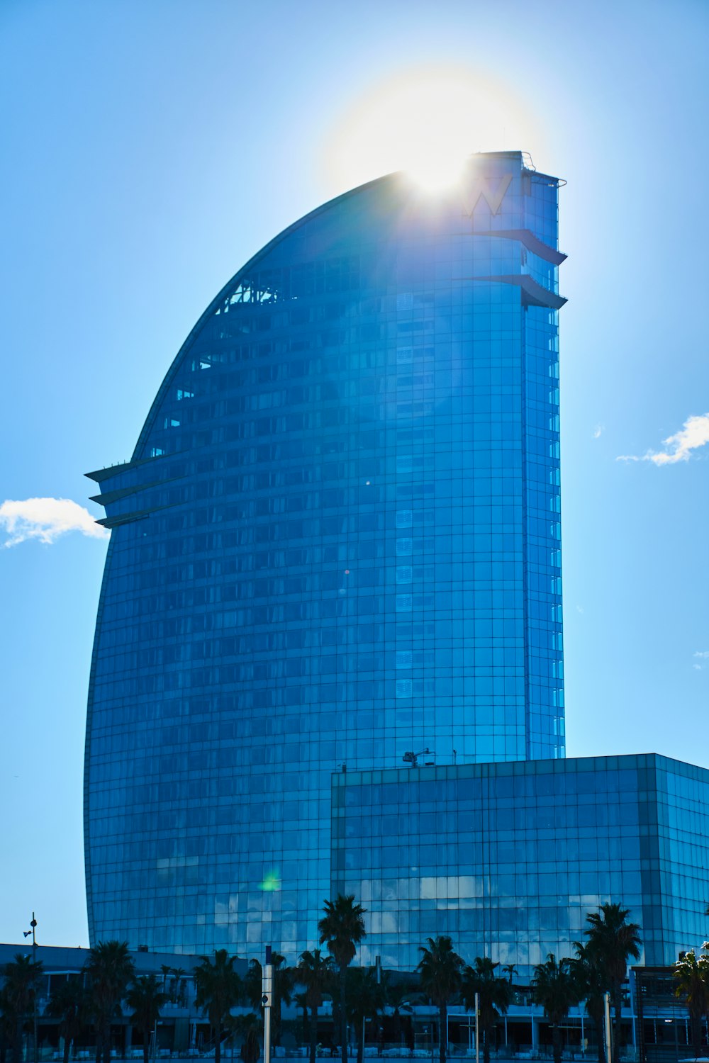 the sun is shining brightly in front of a tall building