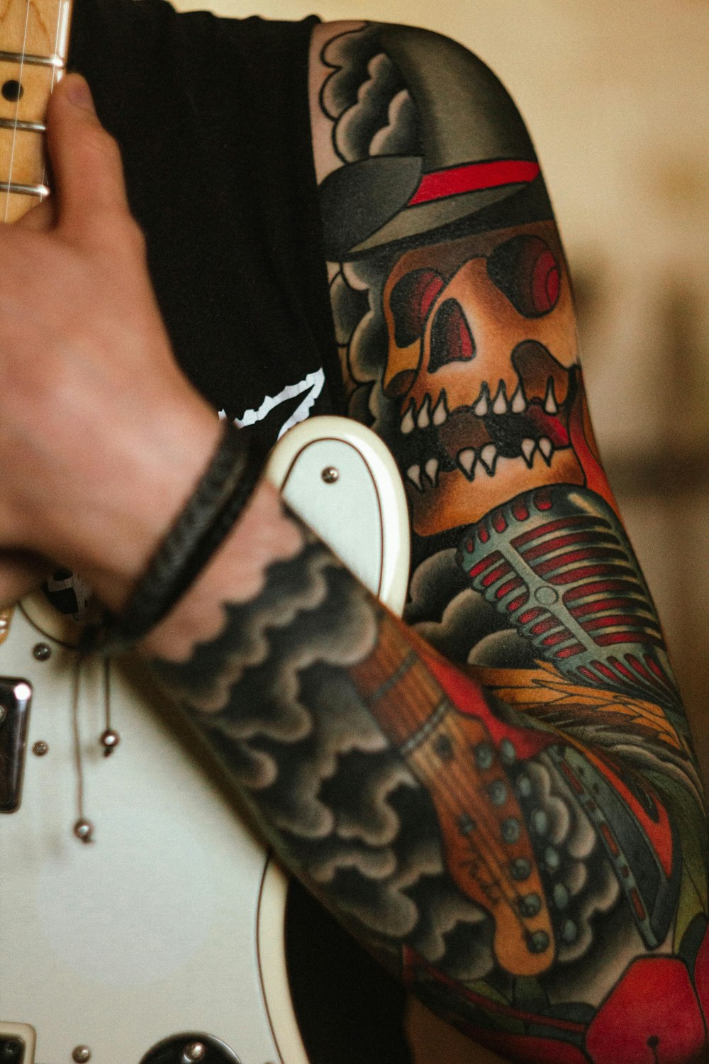 Un uomo con un tatuaggio sul braccio che tiene una chitarra