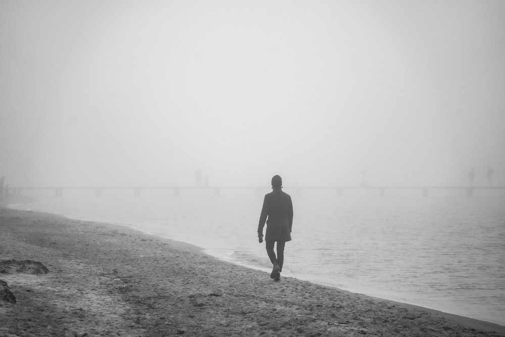 a person walking on a beach in the fog
