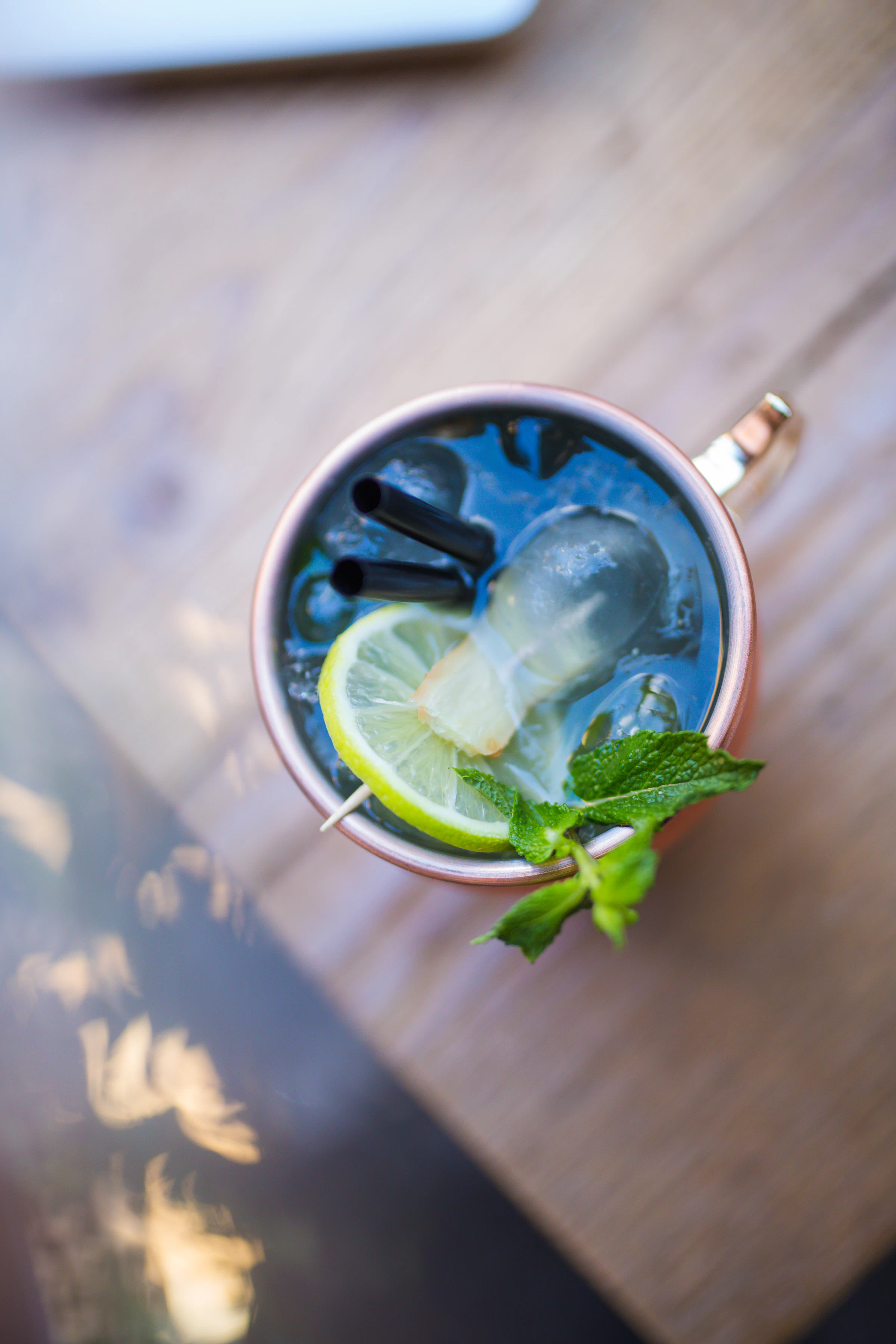 A drink garnished with lime and mint in a glass