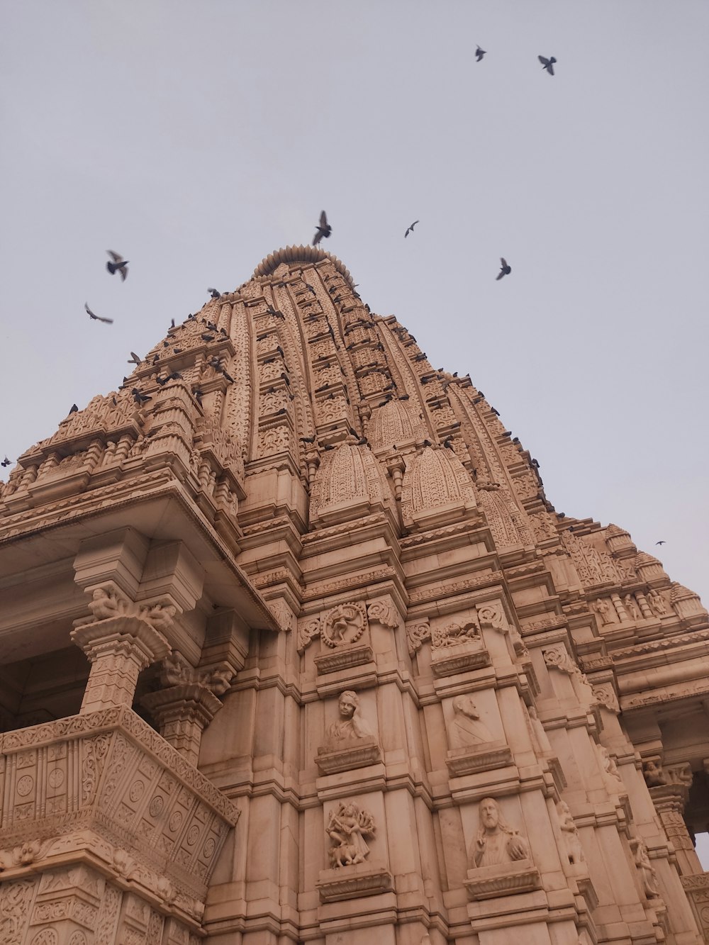 a tall building with birds flying around it