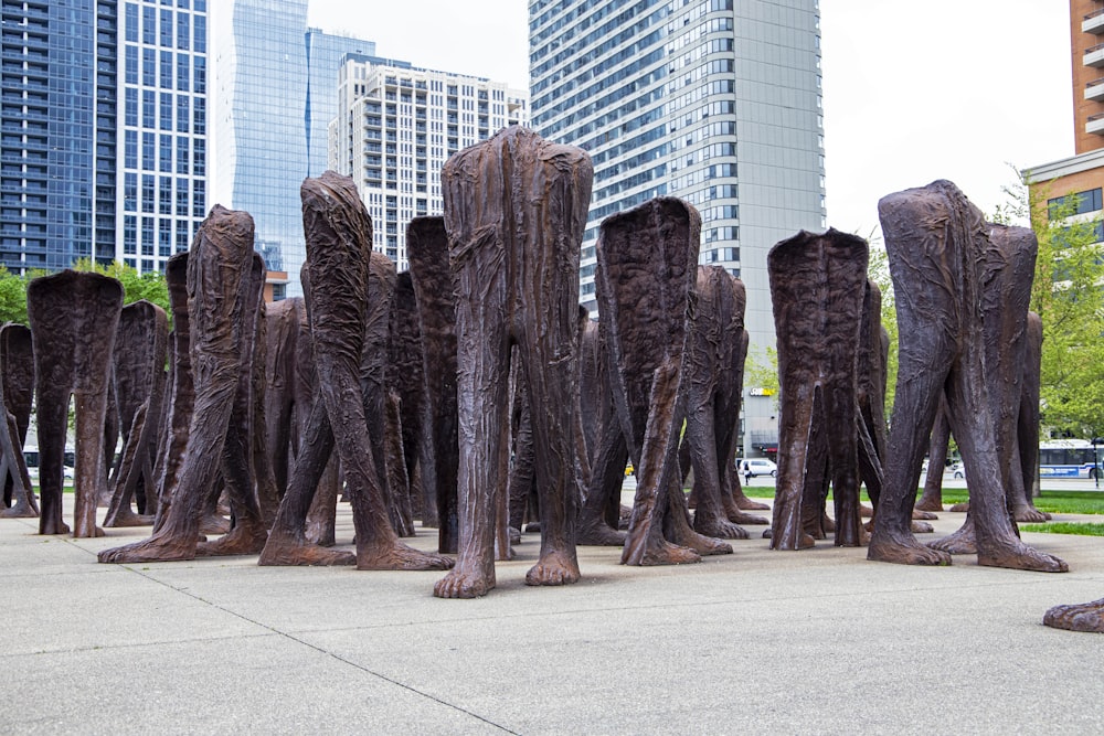 Un grupo de esculturas de madera sentadas encima de una acera