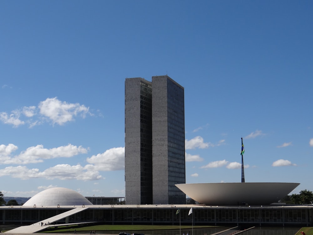 a tall building with a large white bowl in front of it