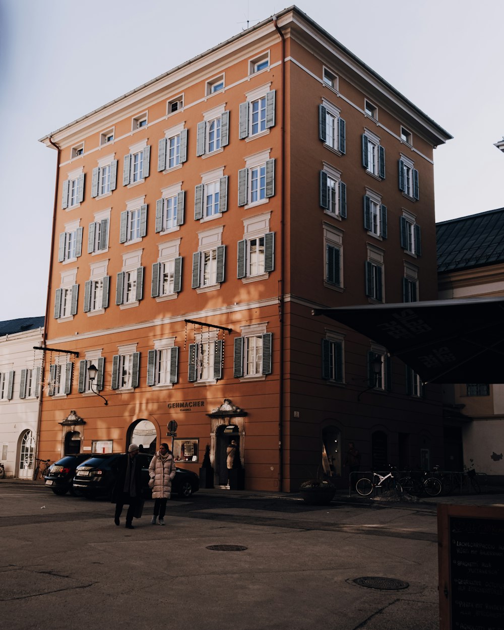 two people walking in front of a tall building