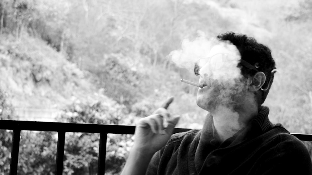 a man smoking a cigarette on a balcony