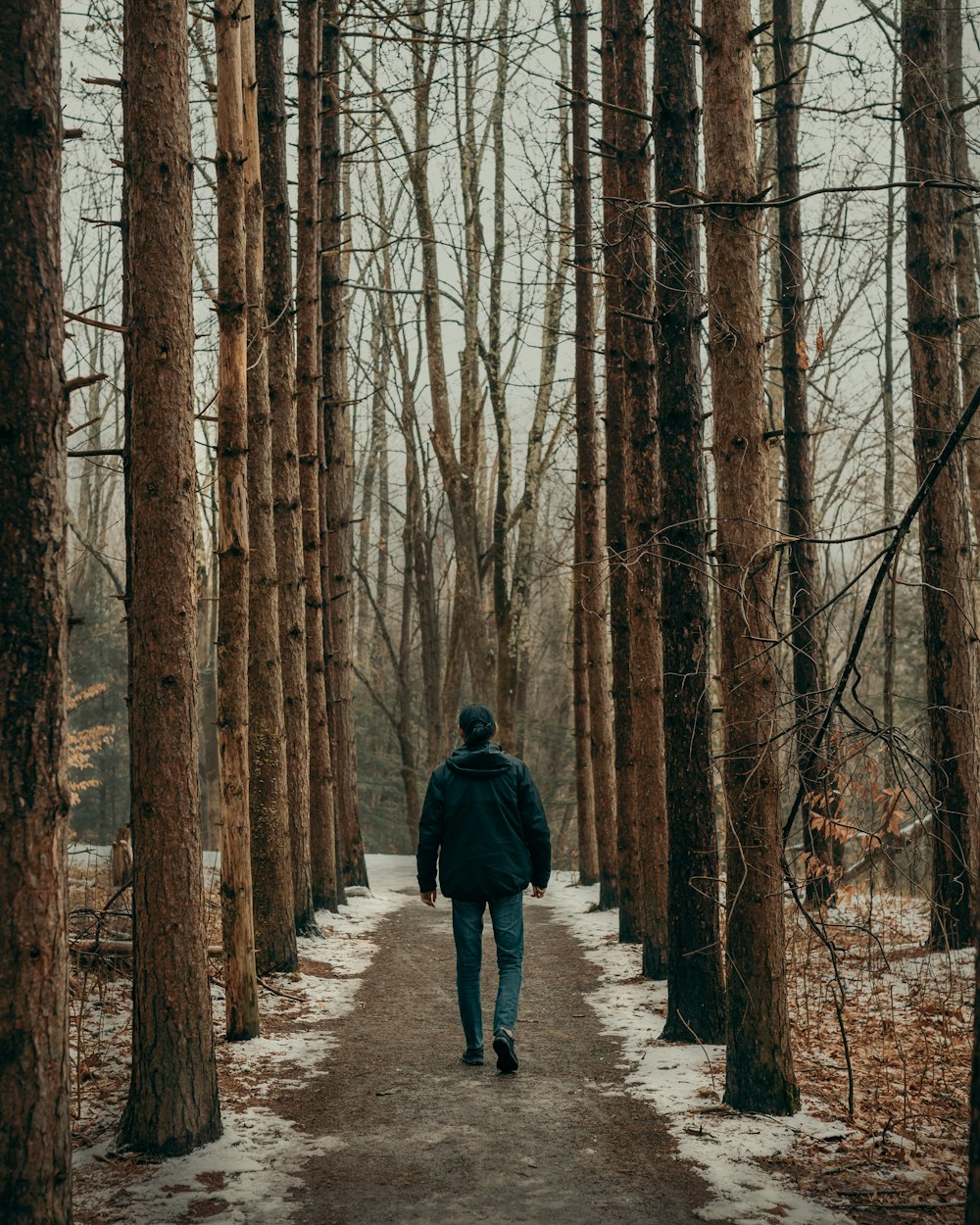 a man standing next to a forest