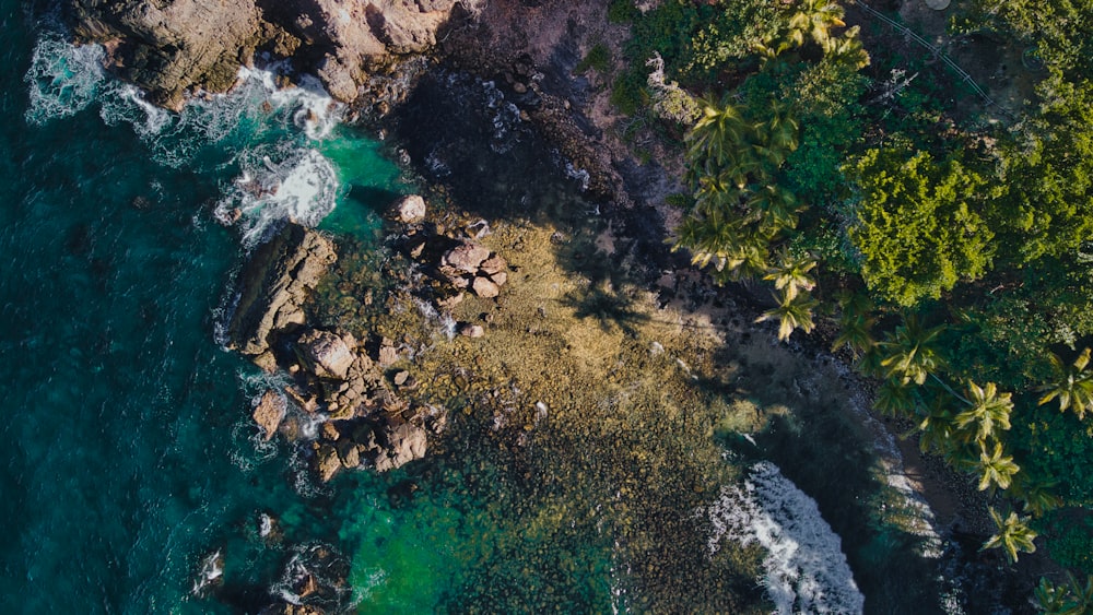 an aerial view of the ocean and rocks