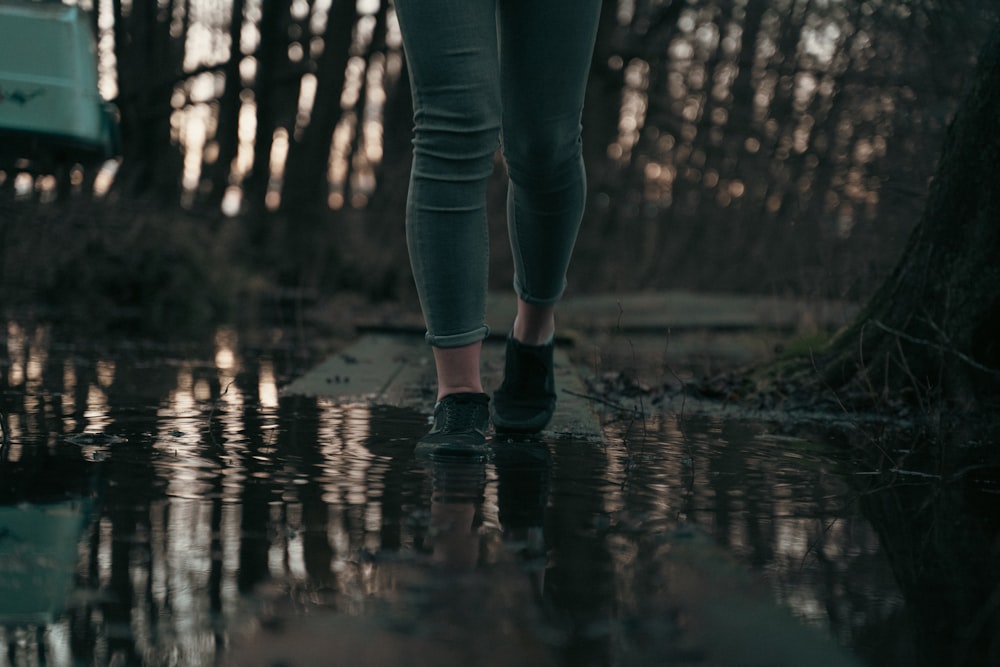 a person walking in the rain with their feet in the water
