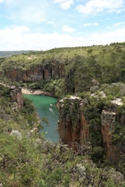 a river in the middle of a lush green valley