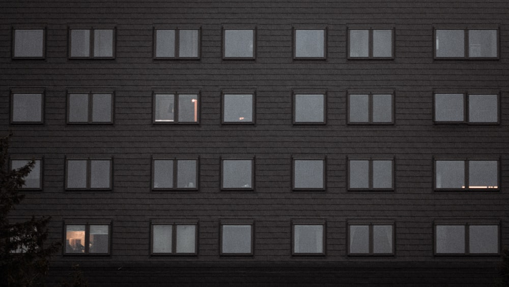 a black building with many windows and a stop sign