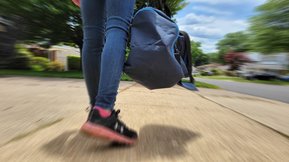 a person walking down a sidewalk with a backpack