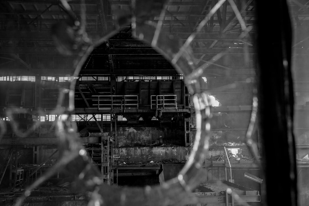a view through a broken glass window of a factory