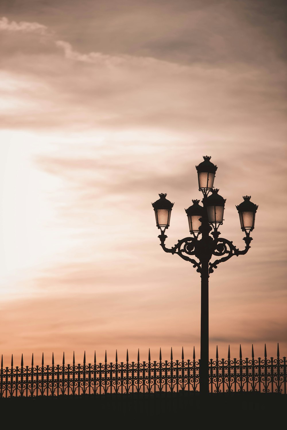 a street light with a fence in the background