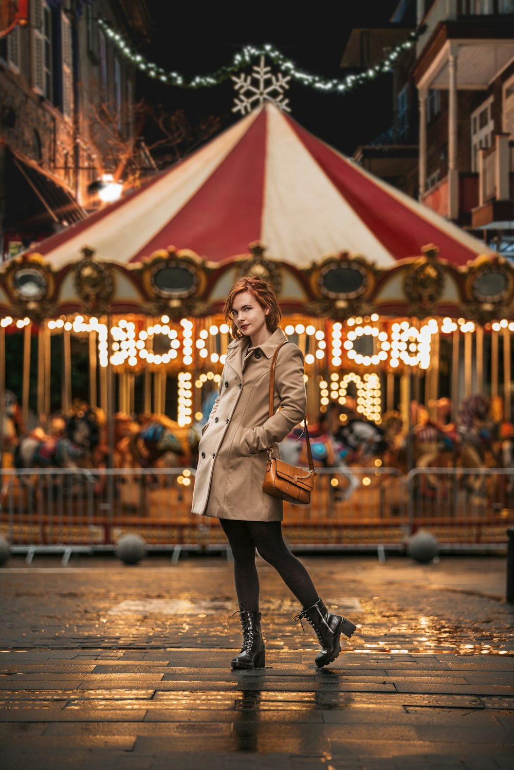 a woman walking down a street in front of a merry - go - round