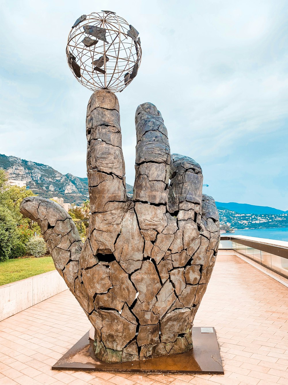 a sculpture of a hand with a globe on top of it