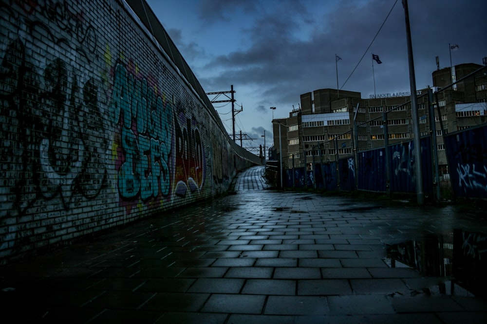 a dark alley way with graffiti on the wall