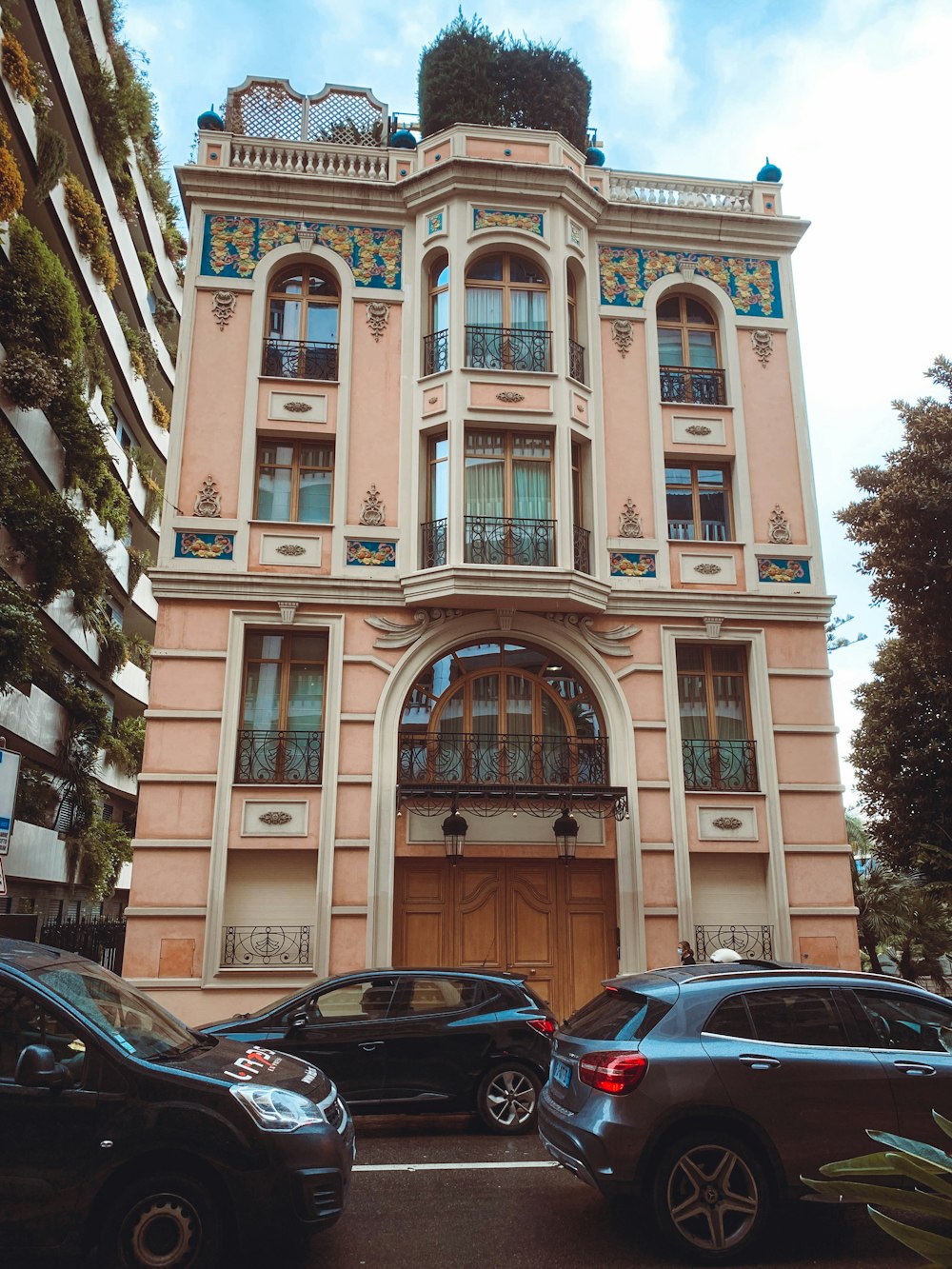 a pink building with a lot of cars parked in front of it