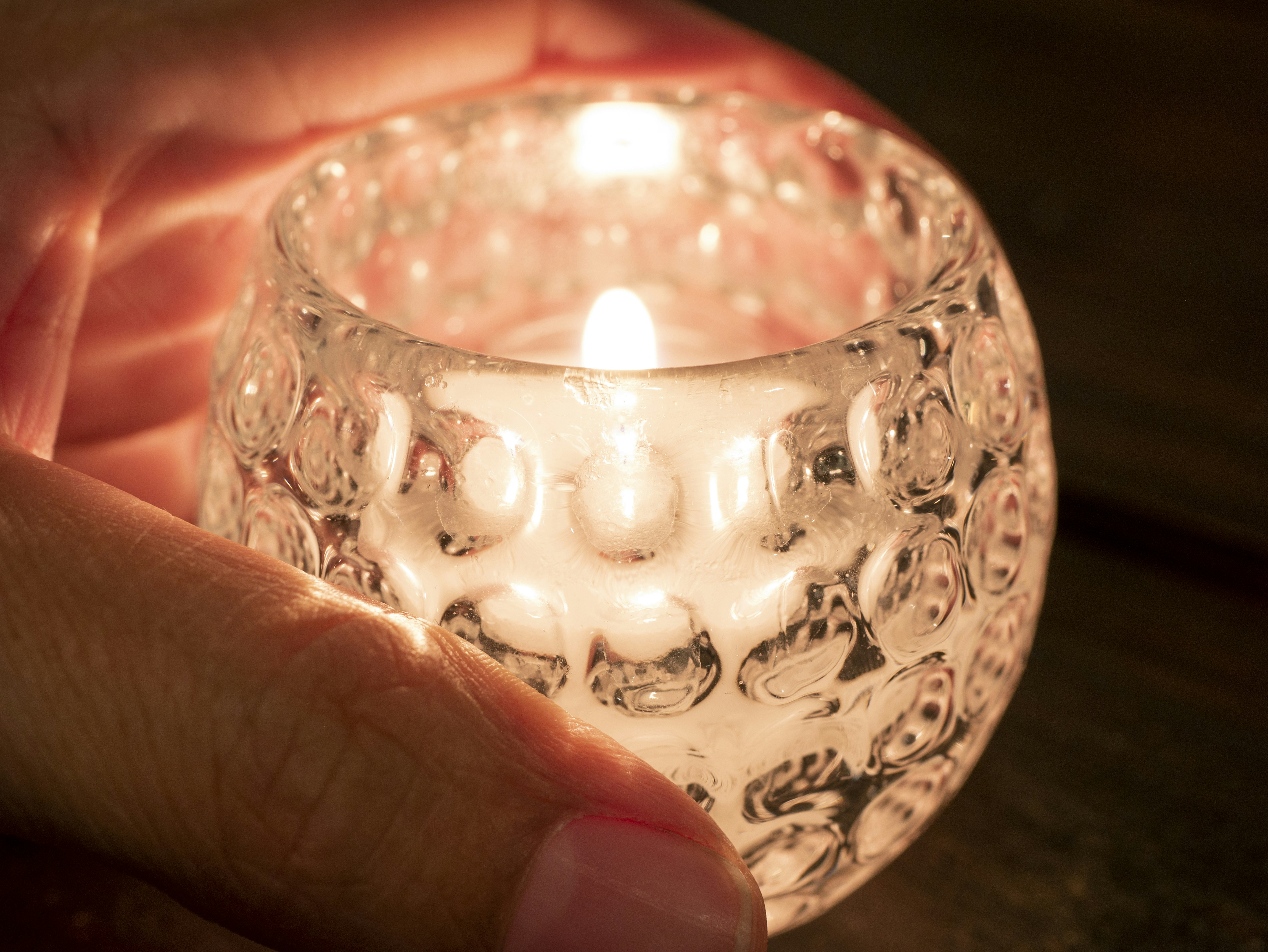 a person holding a lit candle in their hand