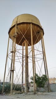 a large water tower sitting on top of a dirt field