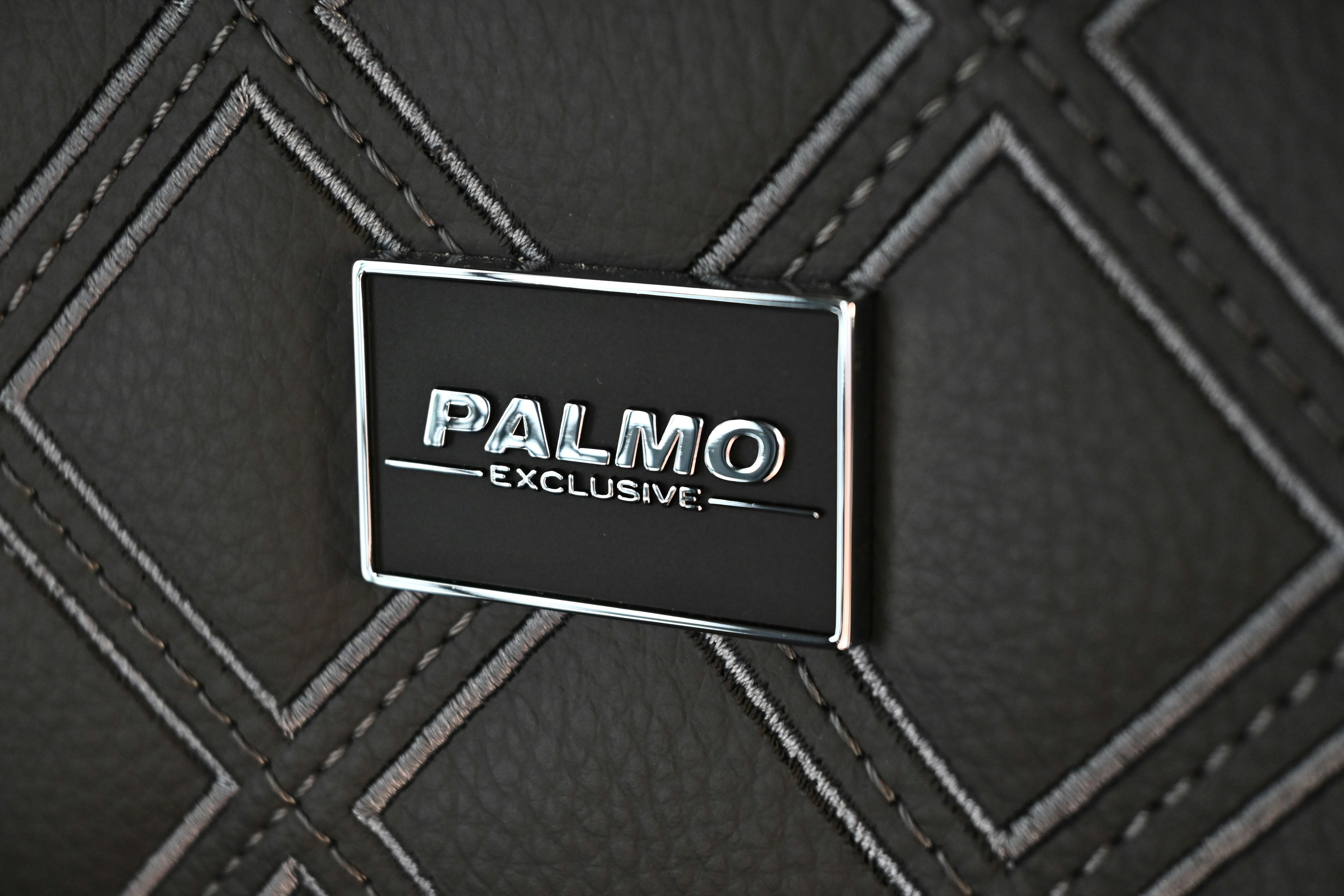 a close up of a logo on a black leather chair