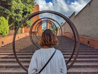 a woman standing in front of a set of stairs