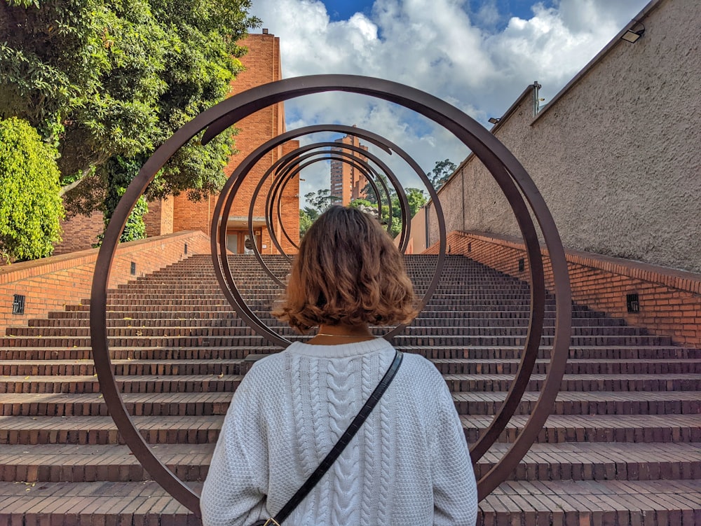 uma mulher em pé na frente de um conjunto de escadas