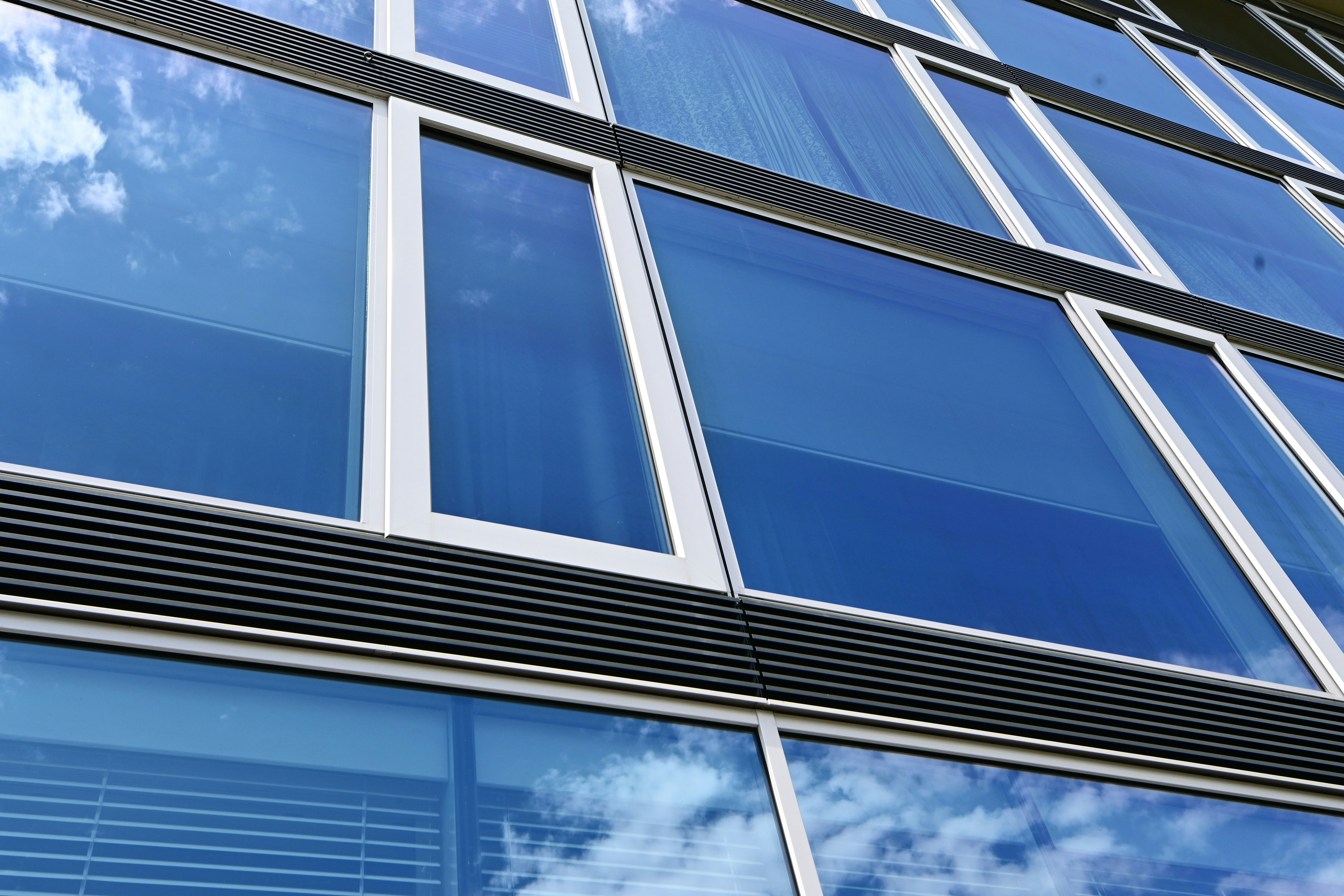 Crystal clear floor-to-ceiling windows in modern building, bright daylight, clean glass with no streaks