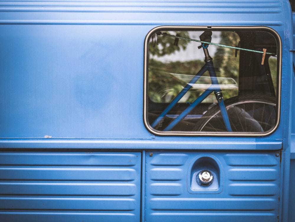 a blue bus with a bike on the back of it