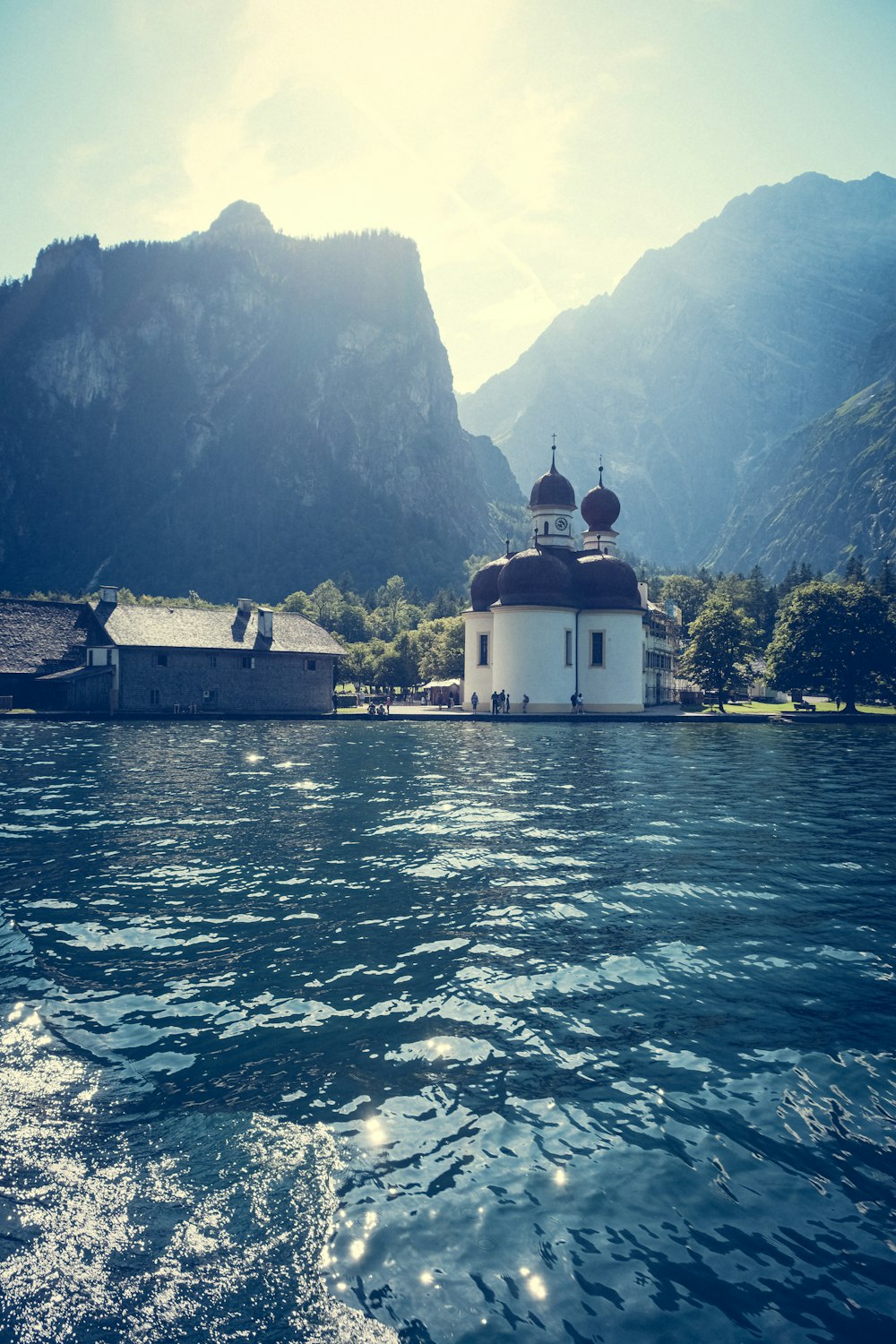 a house on a lake with mountains in the background