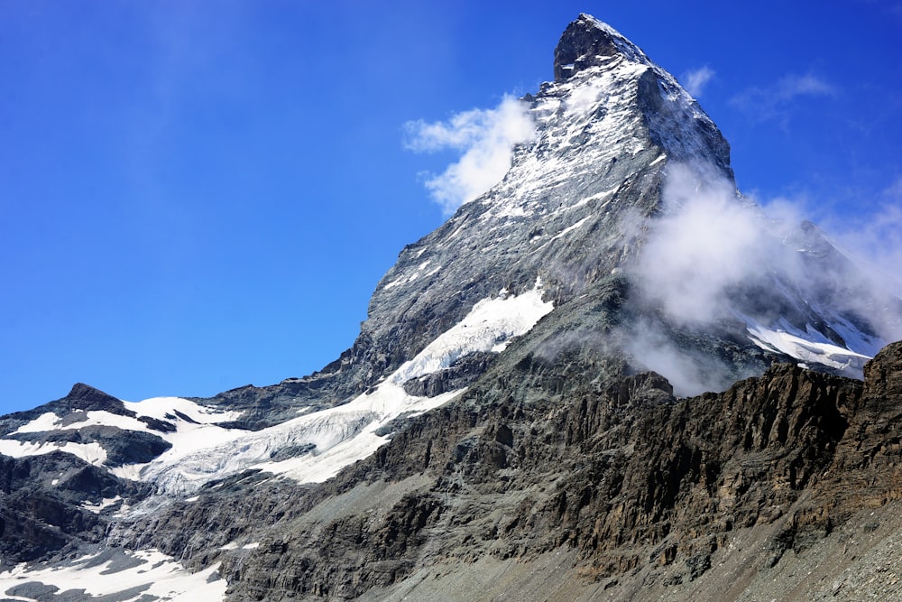 a very tall mountain covered in snow under a blue sky