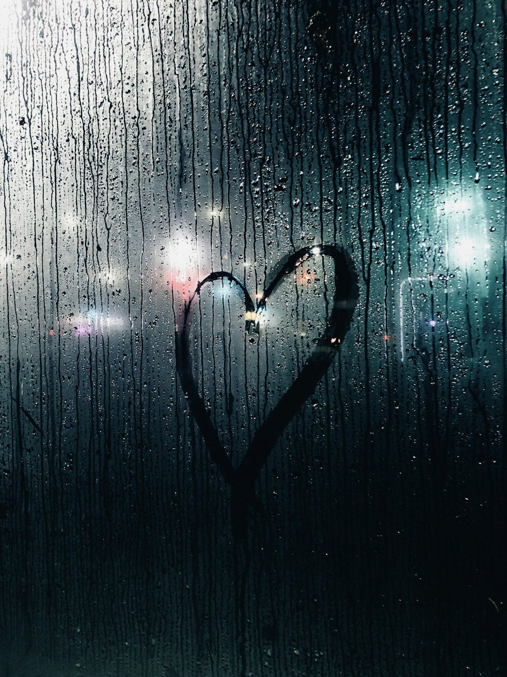a heart drawn in the rain on a window