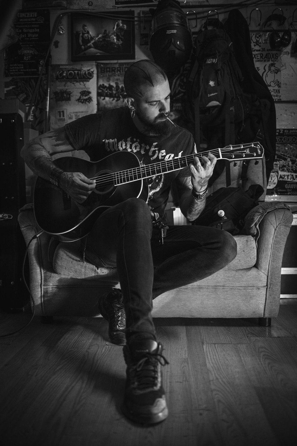 a man sitting on a couch playing a guitar