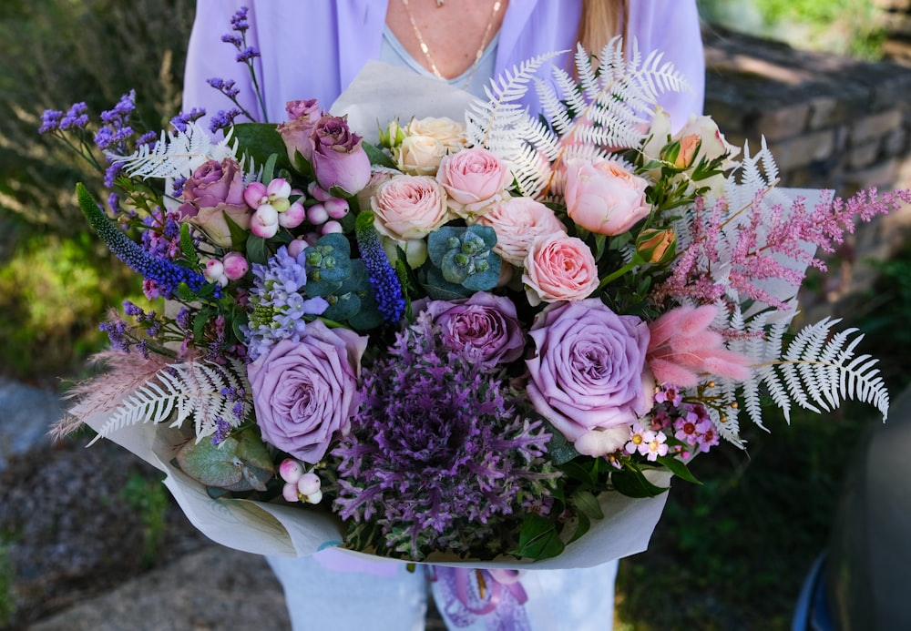 a woman holding a bouquet of flowers in her hands