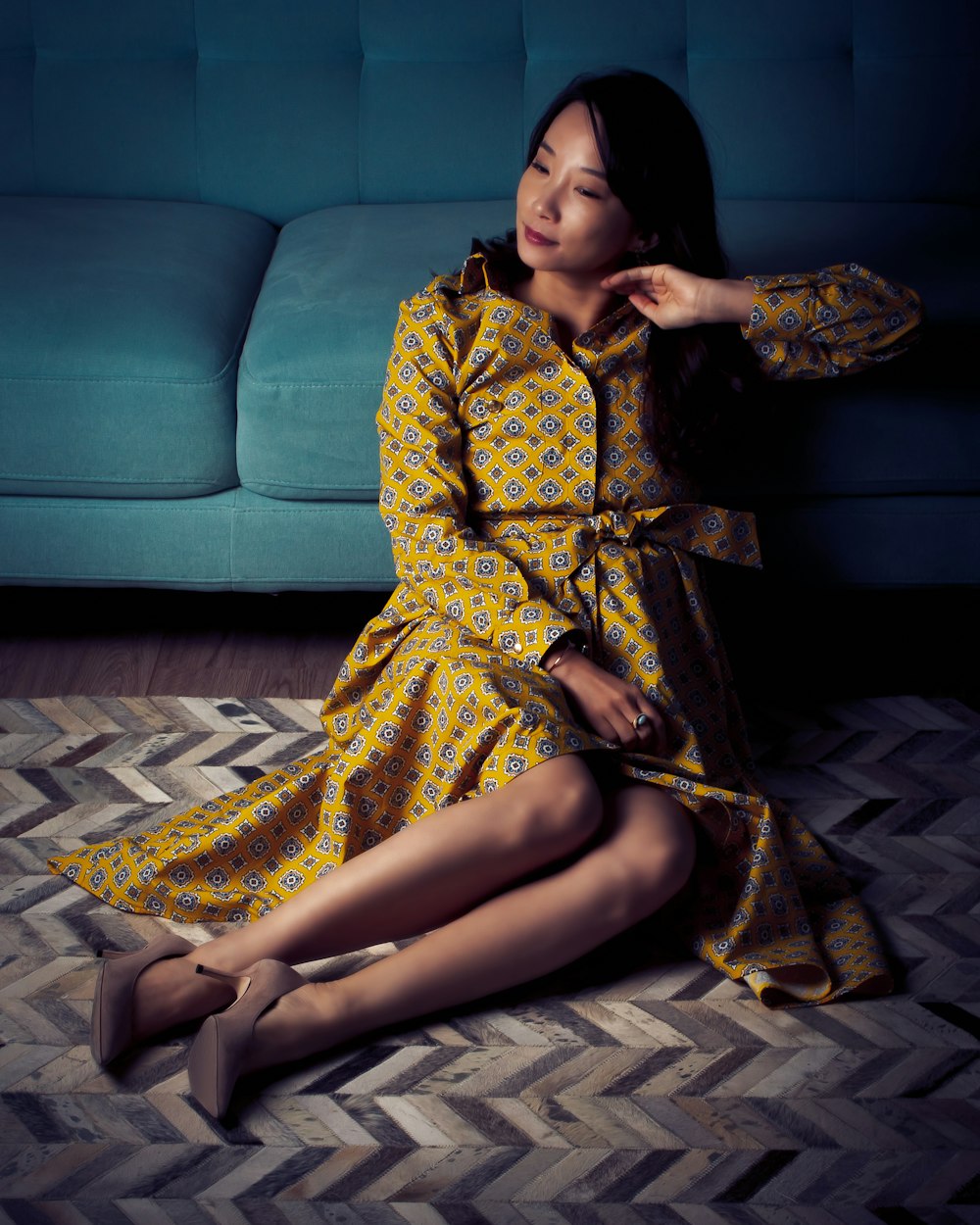 a woman sitting on the floor in a yellow dress