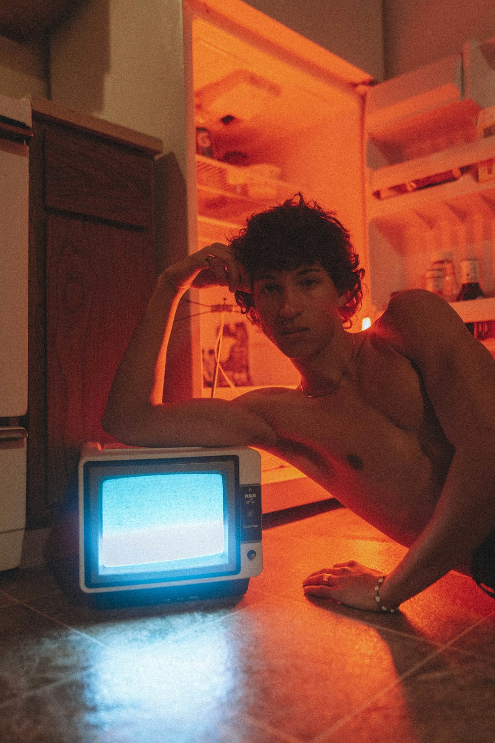 a man sitting on the floor in front of a tv