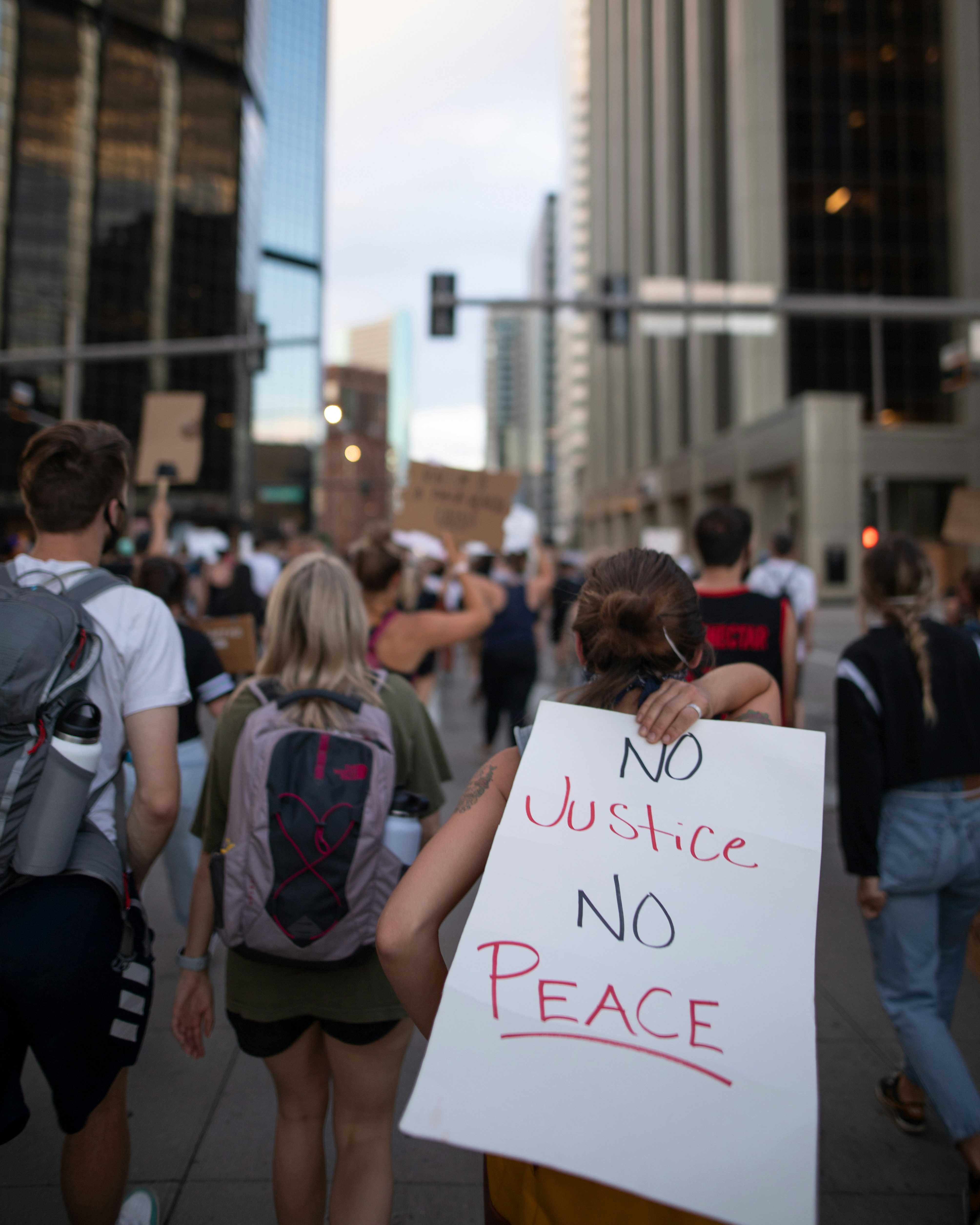 Un grupo de personas caminando por una calle con carteles