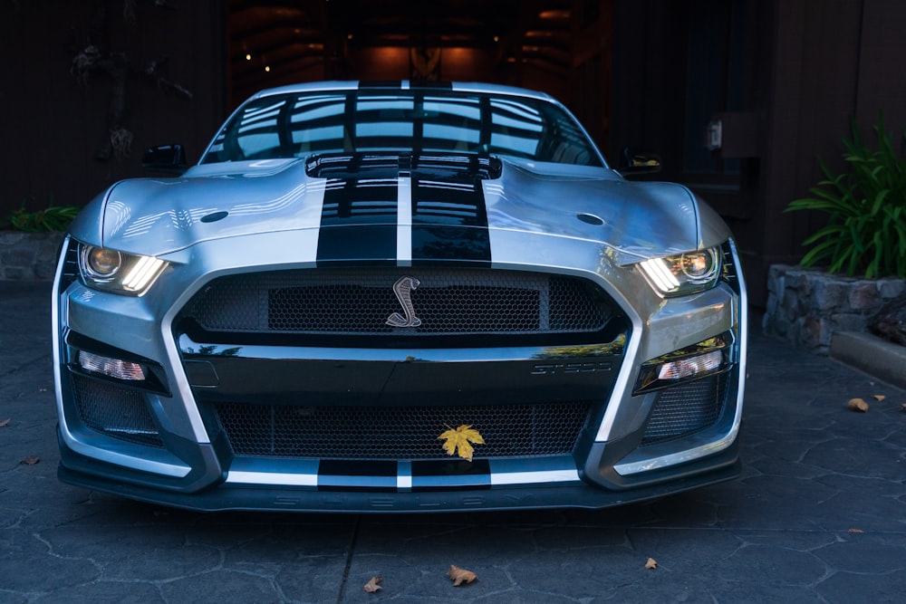 a silver sports car parked in front of a building