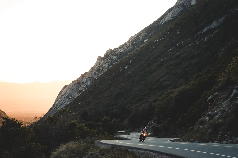 a person riding a motorcycle on a mountain road