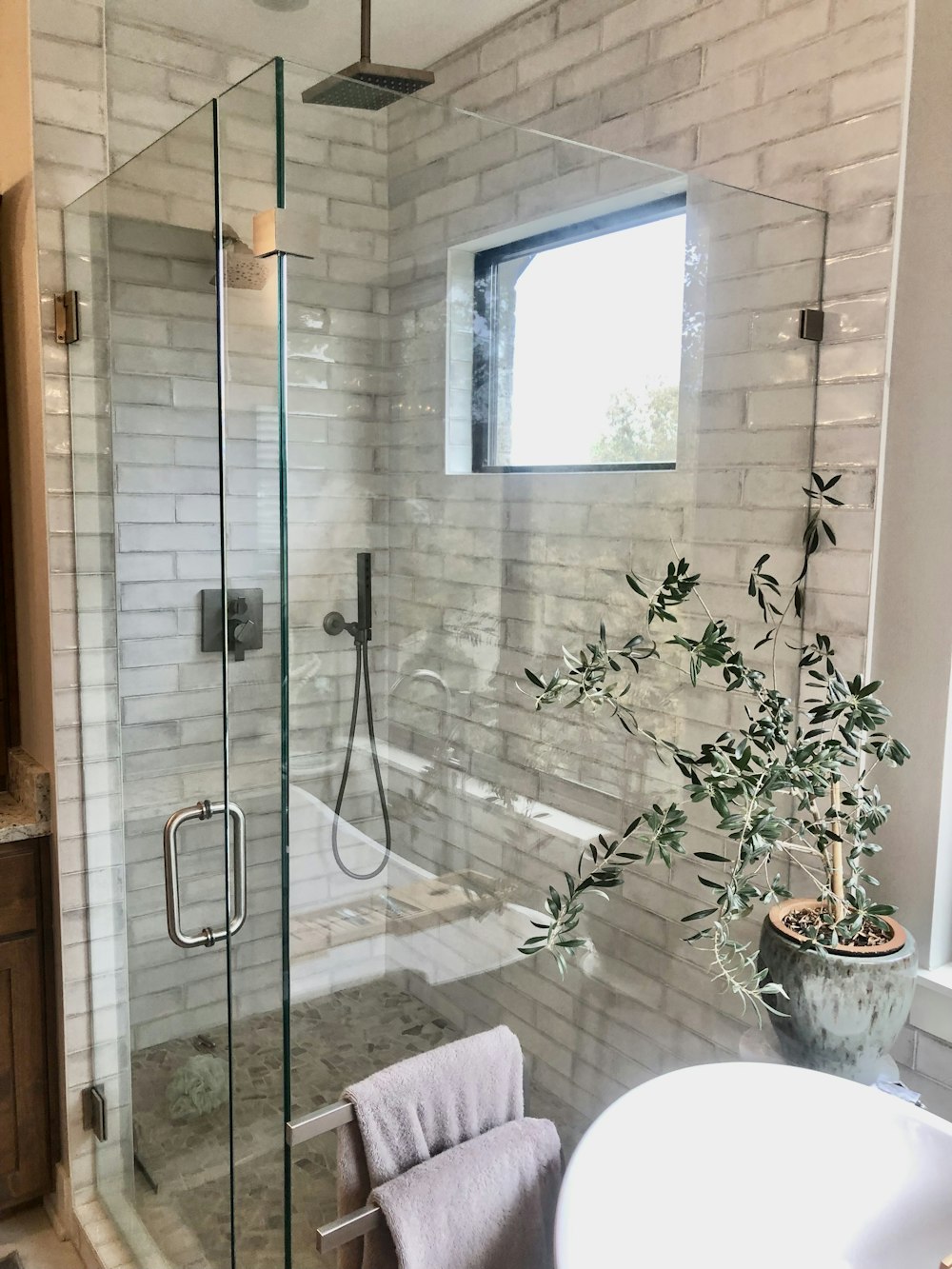 a bathroom with a glass shower door and a sink