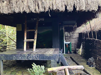 a wooden bench sitting in front of a hut