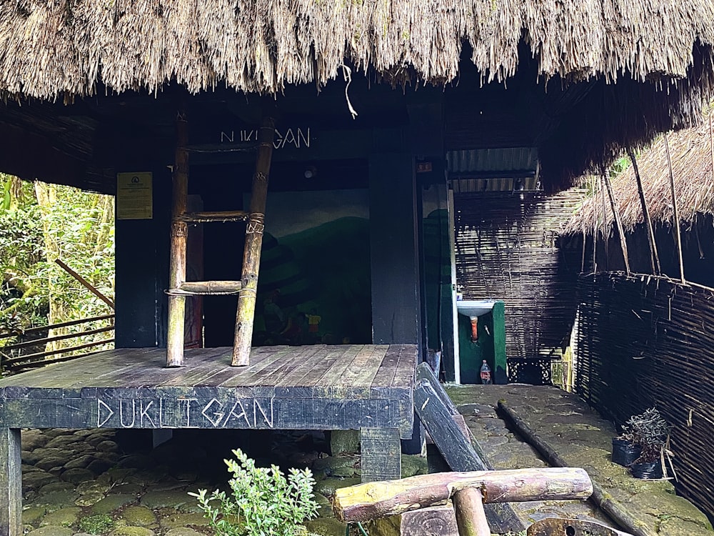 a wooden bench sitting in front of a hut