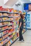 a woman standing in front of a display of food