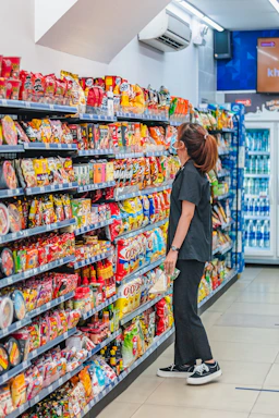 a woman standing in front of a display of food