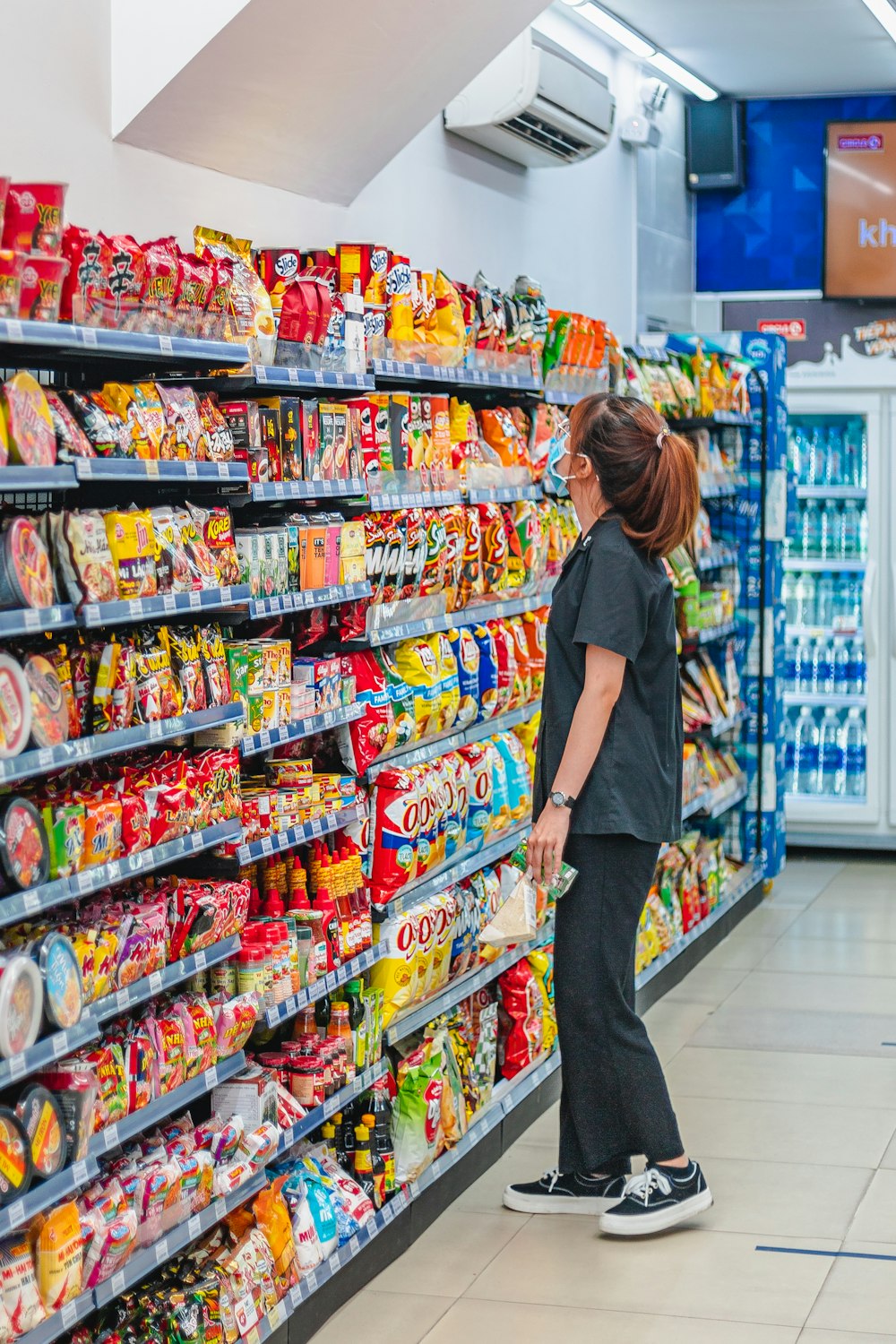 a woman standing in front of a display of food