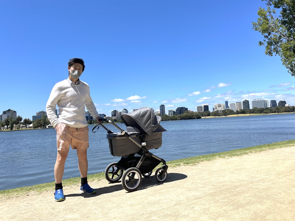 a man standing next to a baby stroller