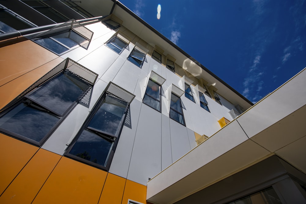 a tall building with lots of windows next to a blue sky