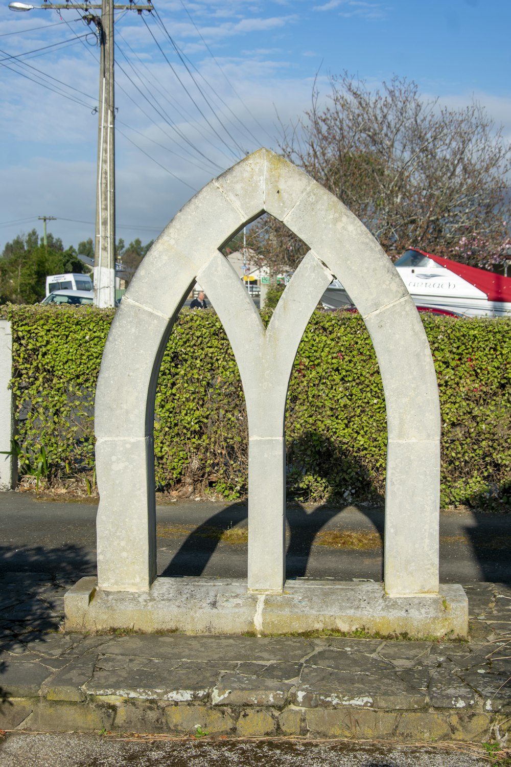 a stone arch sitting on the side of a road