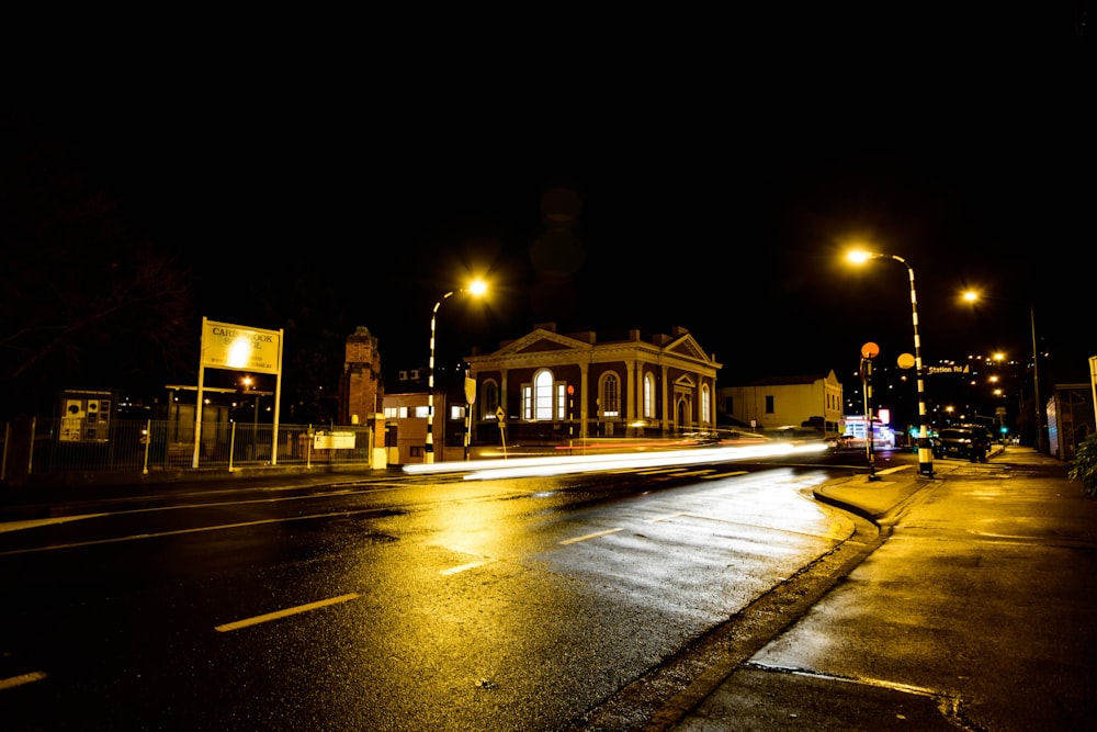 a city street at night with a building lit up