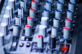 a close up of a sound board with many knobs