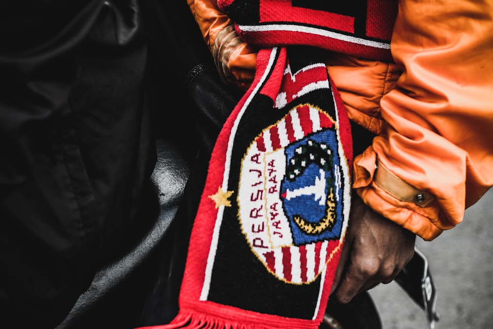 a close up of a person wearing a red and black scarf